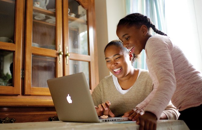 Menina olha como o menino joga o jogo online. dois meninos jogam jogos  online em quarentena. rapazes sorriem e