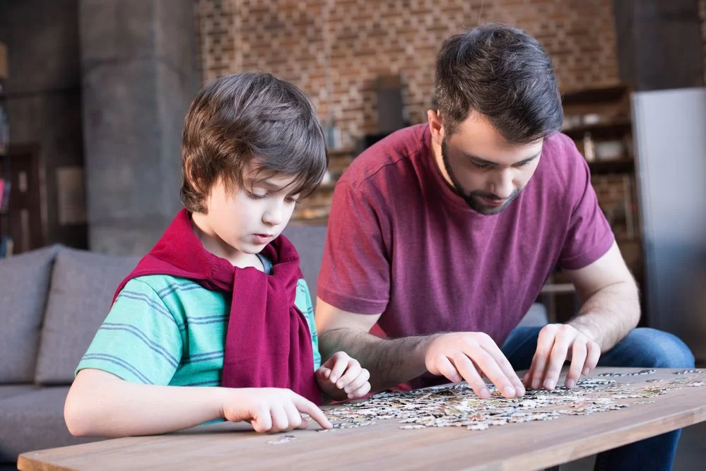 pai incentivando filho a fazer atividades que estimulam a lógica