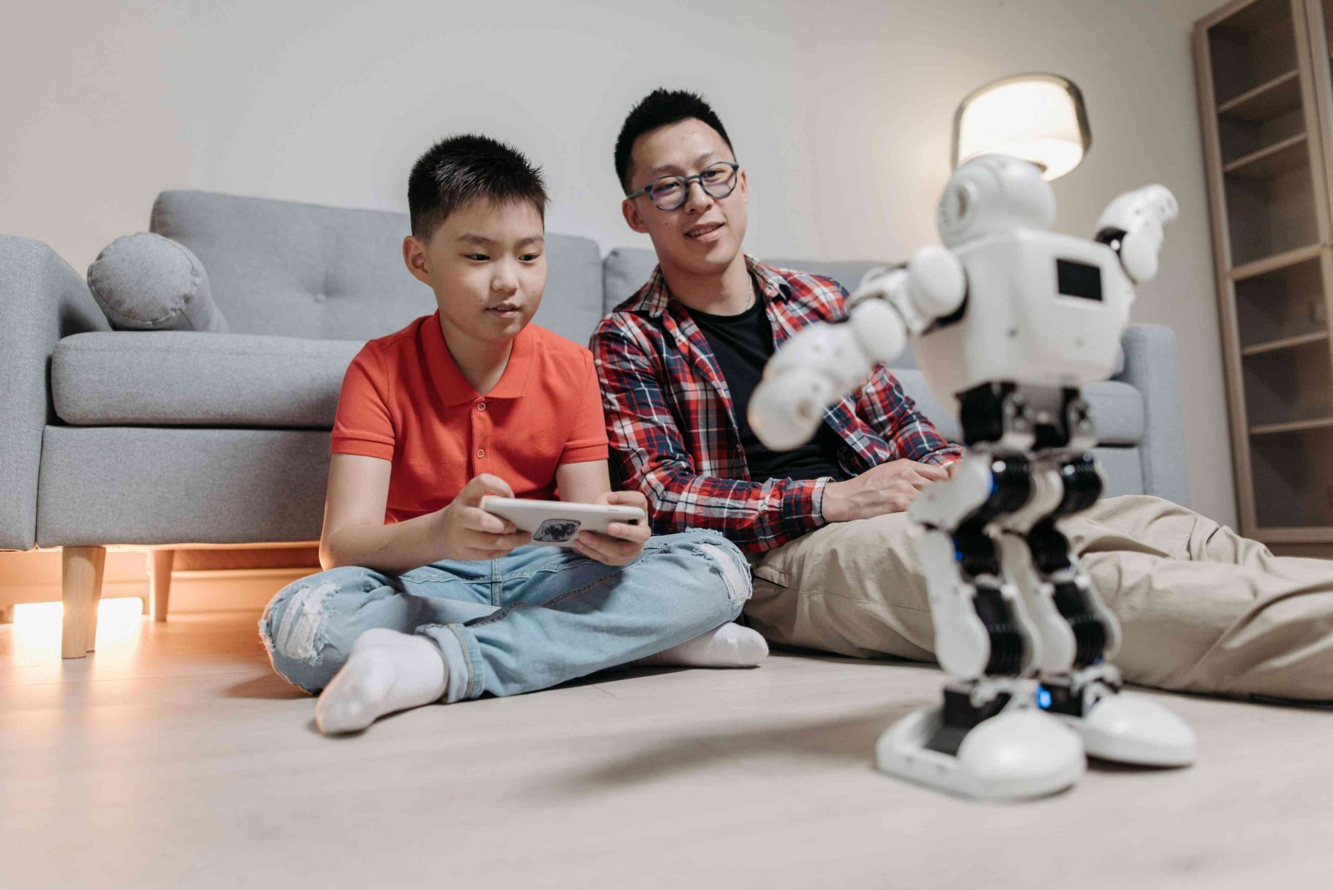 pai e filho brincando com robô na sala